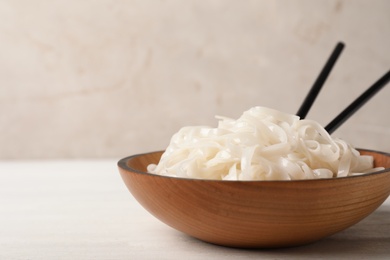 Bowl with rice noodles on table. Space for text