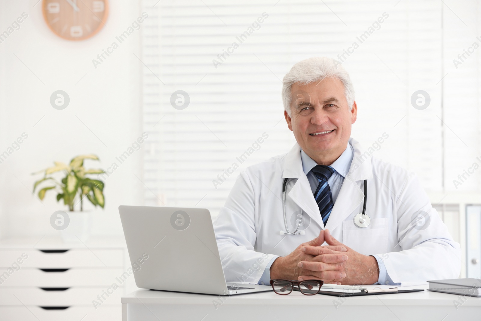 Photo of Portrait of senior doctor in white coat at workplace