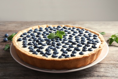 Photo of Tasty cake with blueberry on wooden table