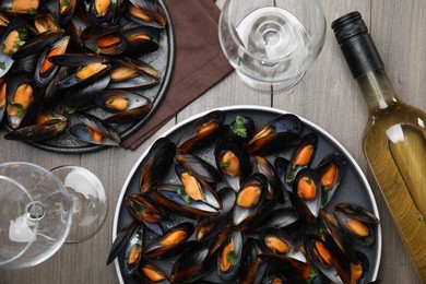 Cooked mussels with parsley and white wine served on wooden table, flat lay