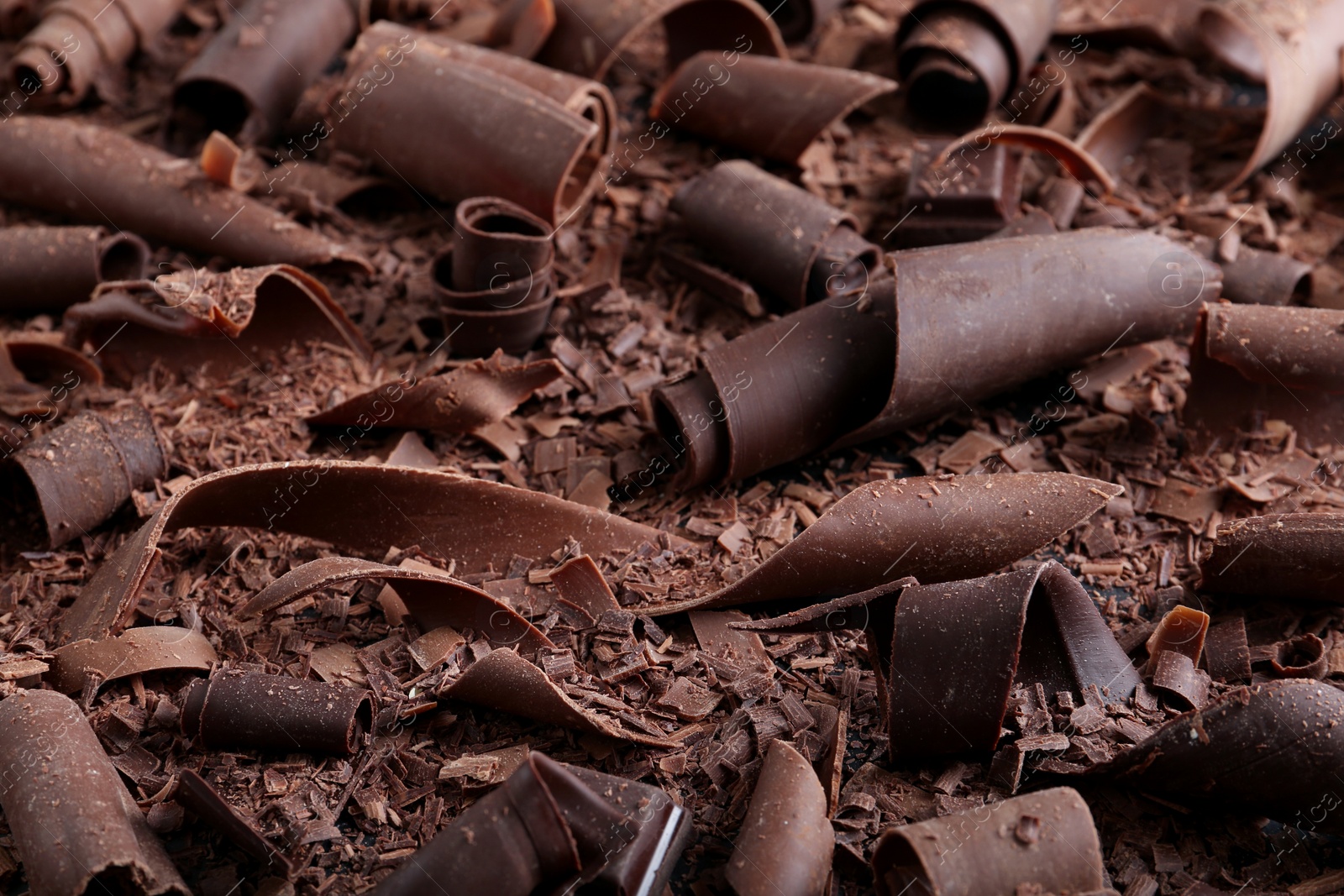 Photo of Yummy chocolate curls for decor as background, closeup