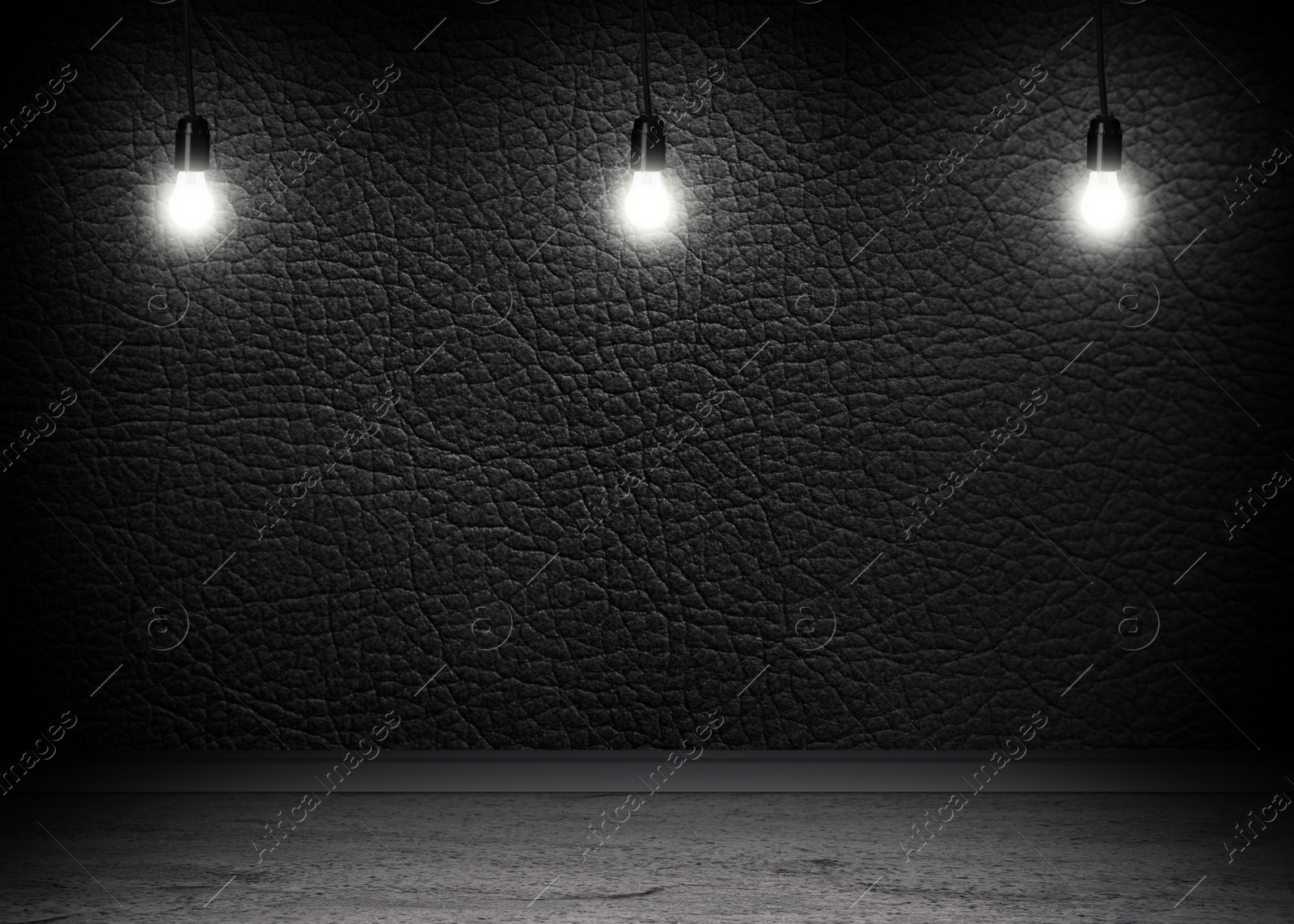 Image of Glowing light bulbs in room with black wall and grey floor