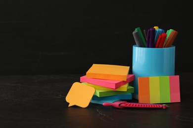 Photo of Different school stationery on stone table near blackboard, space for text. Back to school