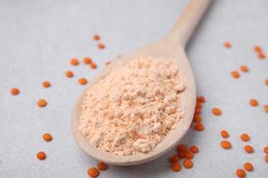 Photo of Spoon of lentil flour and seeds on white table, closeup