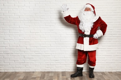 Photo of Authentic Santa Claus against white brick wall. Space for text