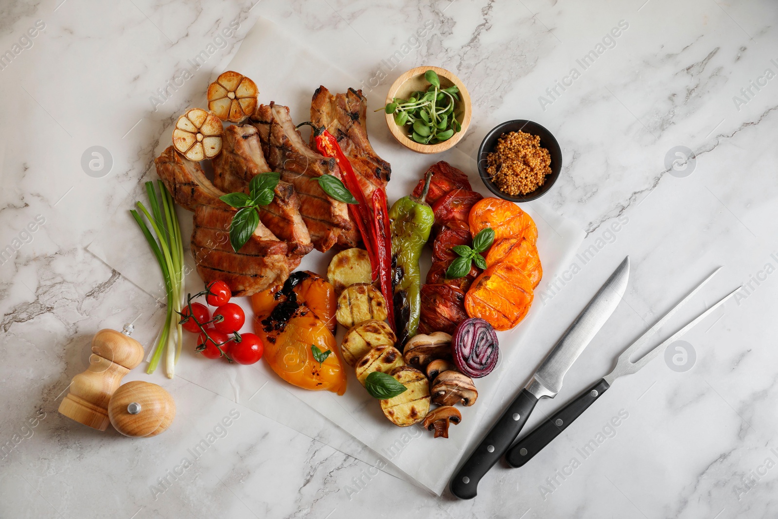 Photo of Delicious grilled meat and vegetables served on white marble table, flat lay