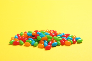 Delicious bright jelly beans on color background