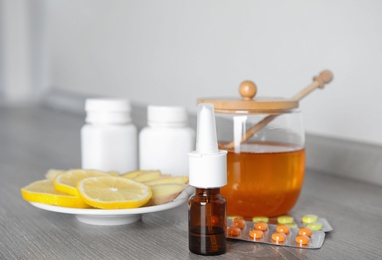 Nasal spray and different cold remedies on wooden table