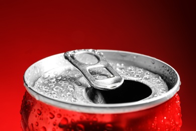 Photo of Wet open can on red background, closeup