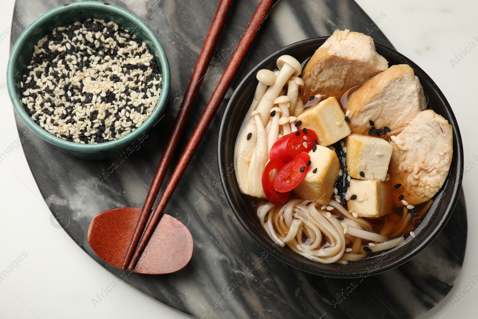 Photo of Delicious ramen served on white table, top view. Noodle soup