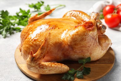 Photo of Tasty roasted chicken with parsley on light grey table