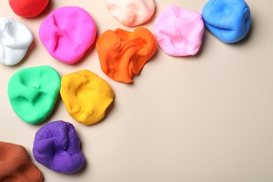 Photo of Colorful plasticine on beige background, flat lay. Space for text