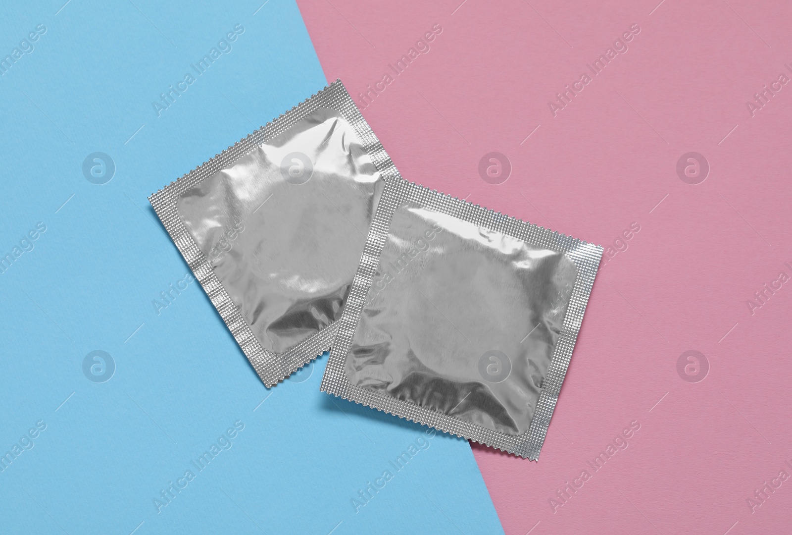 Photo of Condom packages on color background, flat lay. Safe sex