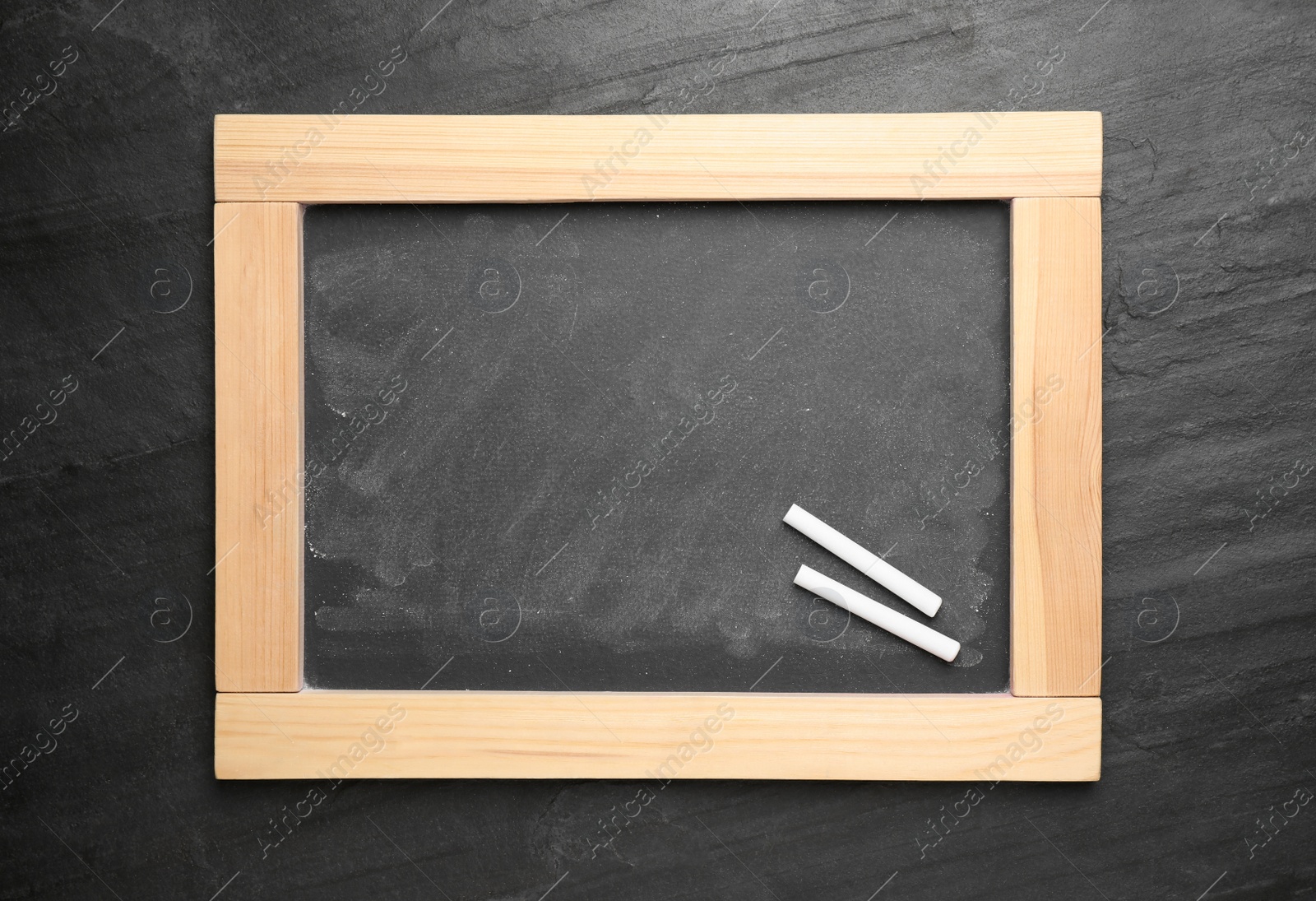 Photo of Empty blackboard with chalk on slate background, top view. Space for text