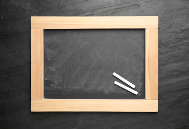 Empty blackboard with chalk on slate background, top view. Space for text