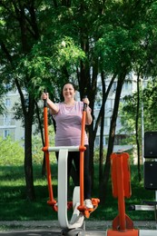Overweight woman doing exercise with air walker in park