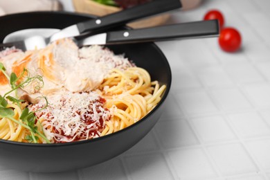 Delicious pasta with tomato sauce, chicken and parmesan cheese on white tiled table, closeup. Space for text