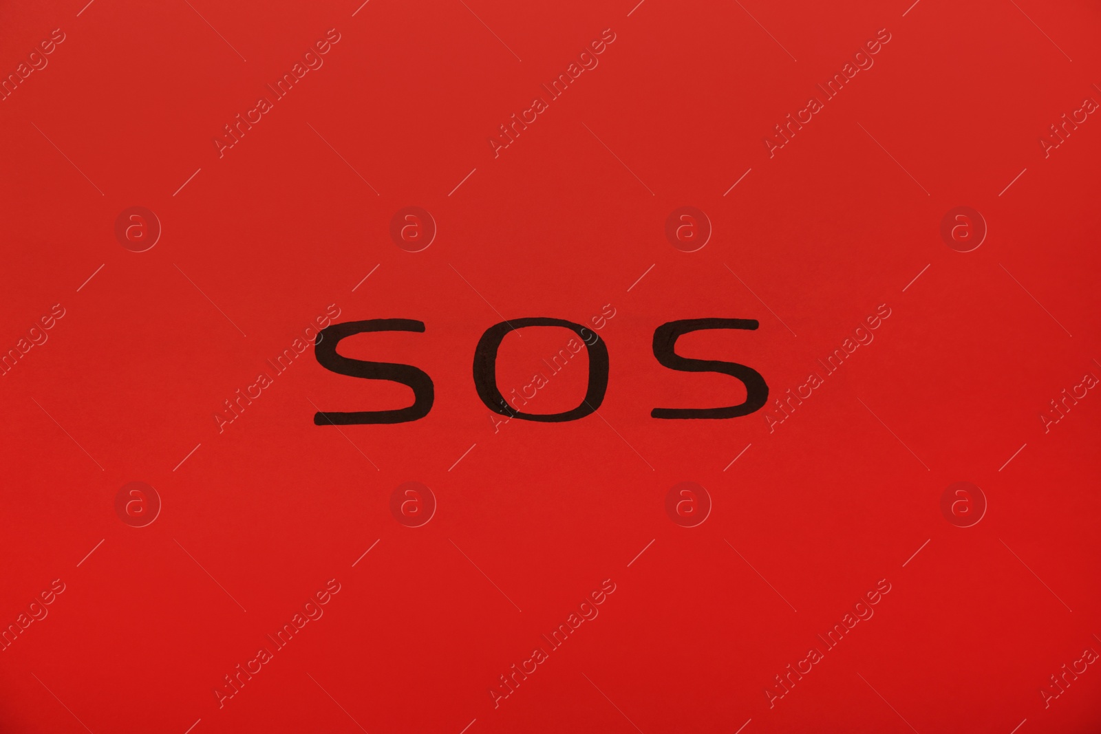 Photo of Abbreviation SOS (Save Our Souls) written on red background, top view