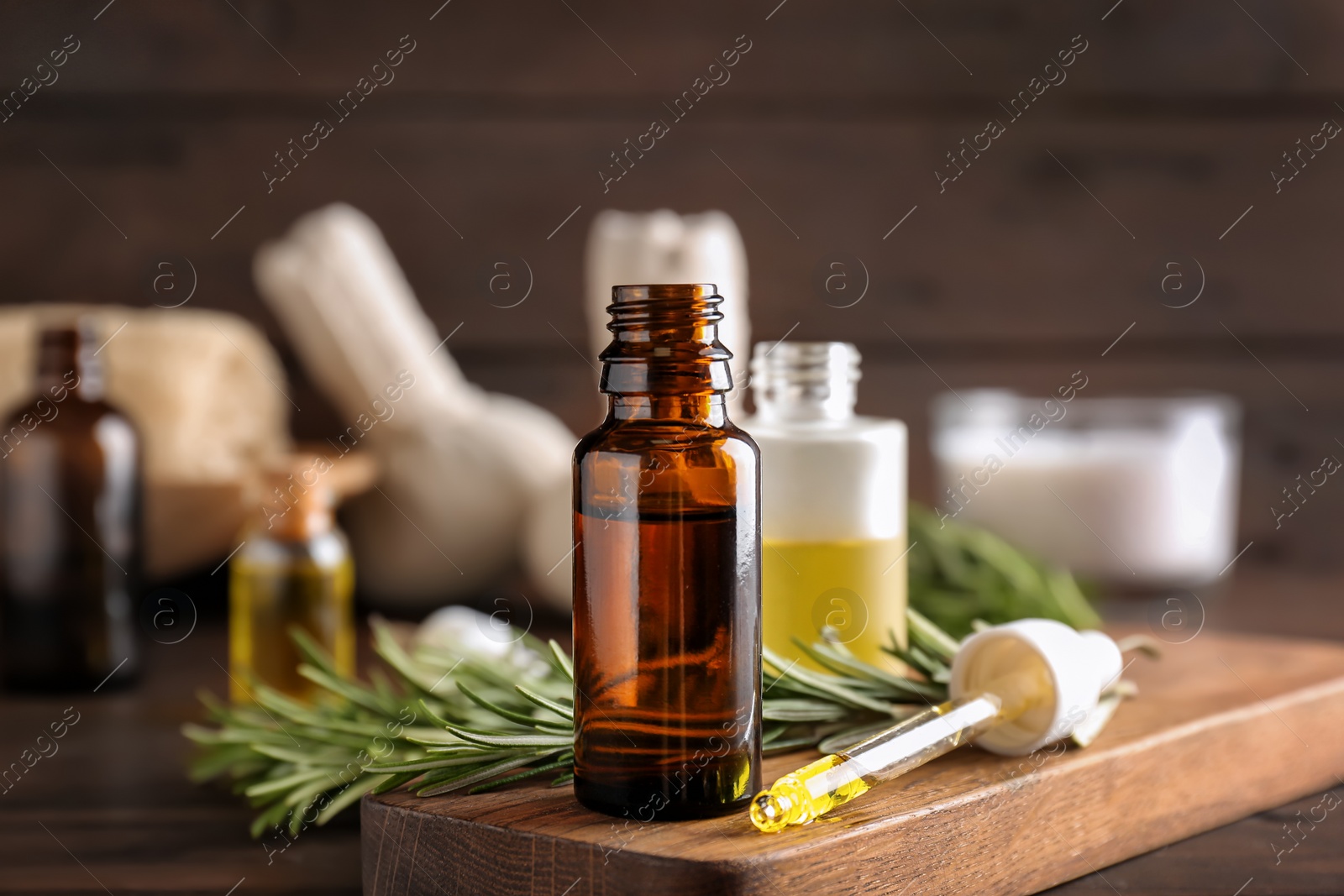 Photo of Bottle with essential oil on wooden board