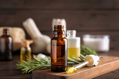 Bottle with essential oil on wooden board