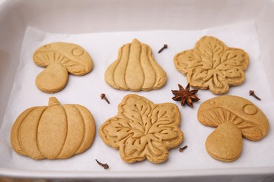 Photo of Different tasty cookies and spices on white parchment