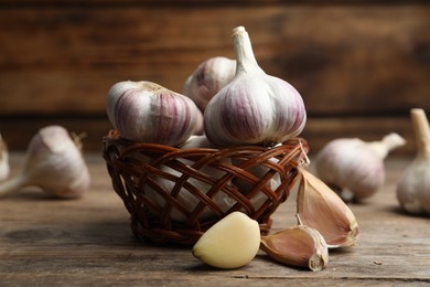 Fresh organic garlic in wicker basket on wooden table