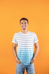 Photo of Portrait of handsome young man smiling on color background