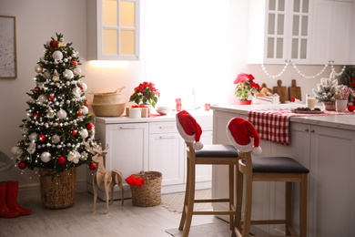 Photo of Beautiful kitchen interior with Christmas tree and festive decor