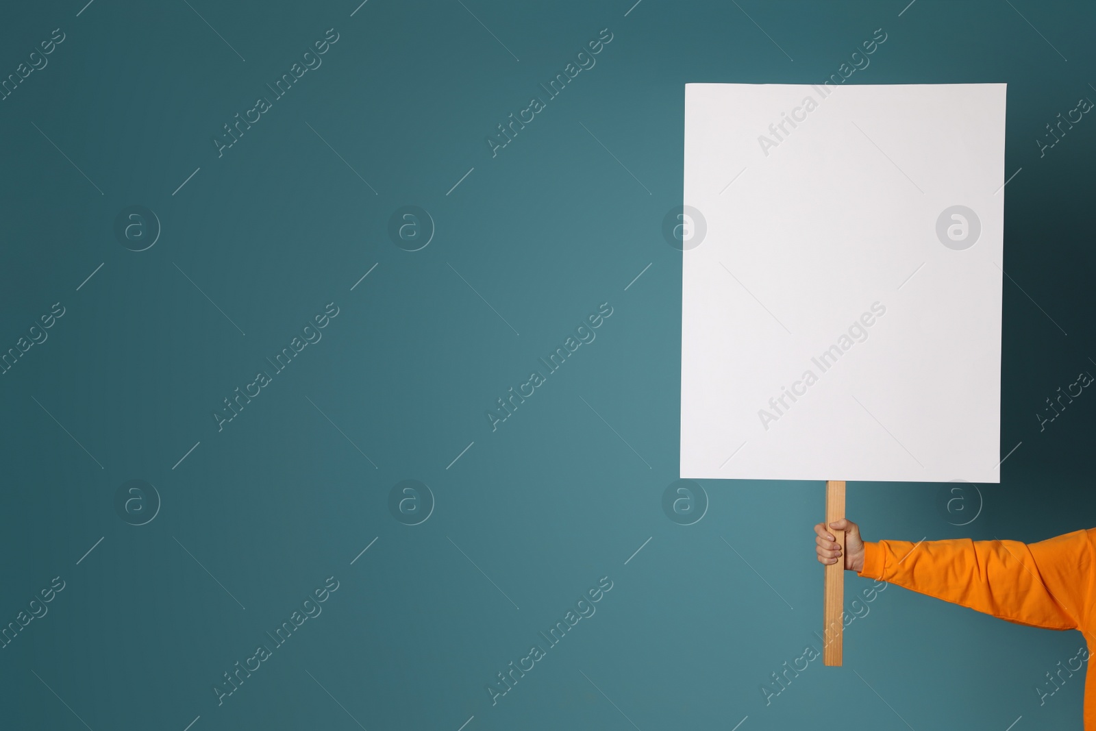 Photo of Woman holding blank sign on light blue background, closeup. Space for design