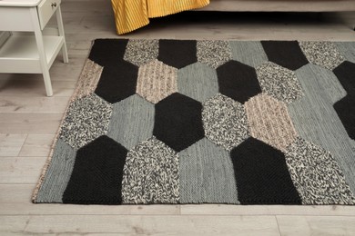 Carpet with geometric pattern on wooden floor in room