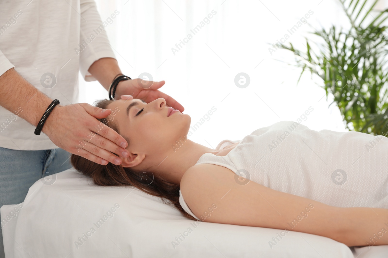 Photo of Young woman during crystal healing session in therapy room