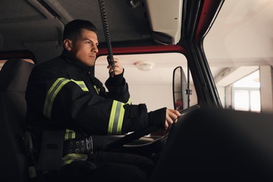 Firefighter using radio set while driving fire truck