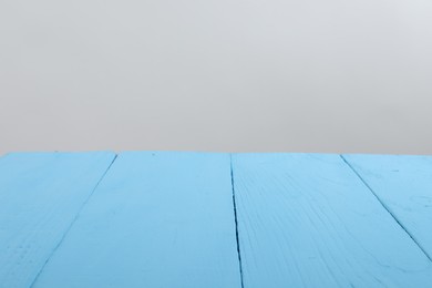 Photo of Empty light blue wooden surface on white background. Space for text