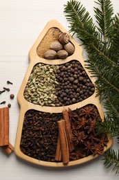 Photo of Different spices, nuts and fir branches on white wooden table, flat lay