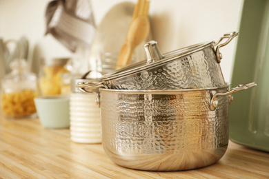 Photo of Metal pots on wooden countertop in kitchen