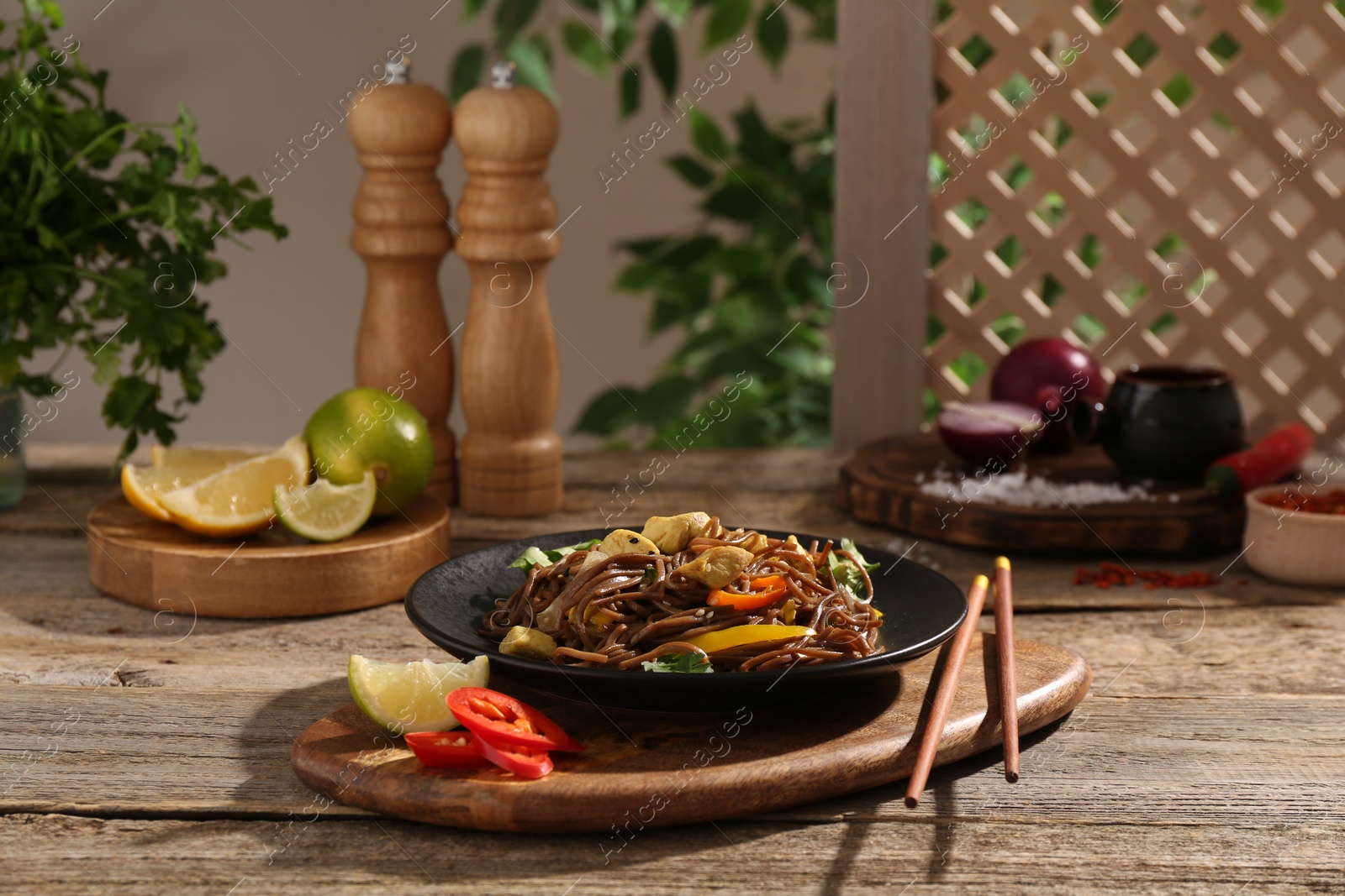 Photo of Stir-fry. Tasty noodles with meat and vegetables served on wooden table