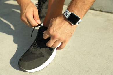 Man wearing modern smart watch during training outdoors, closeup