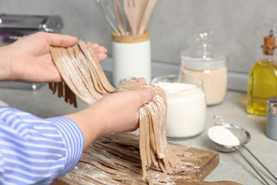 Photo of Woman making soba at table in kitchen, closeup