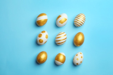 Photo of Flat lay composition of traditional Easter eggs decorated with golden paint on color background