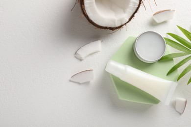 Lip balms, coconut and leaves on white background, flat lay. Space for text