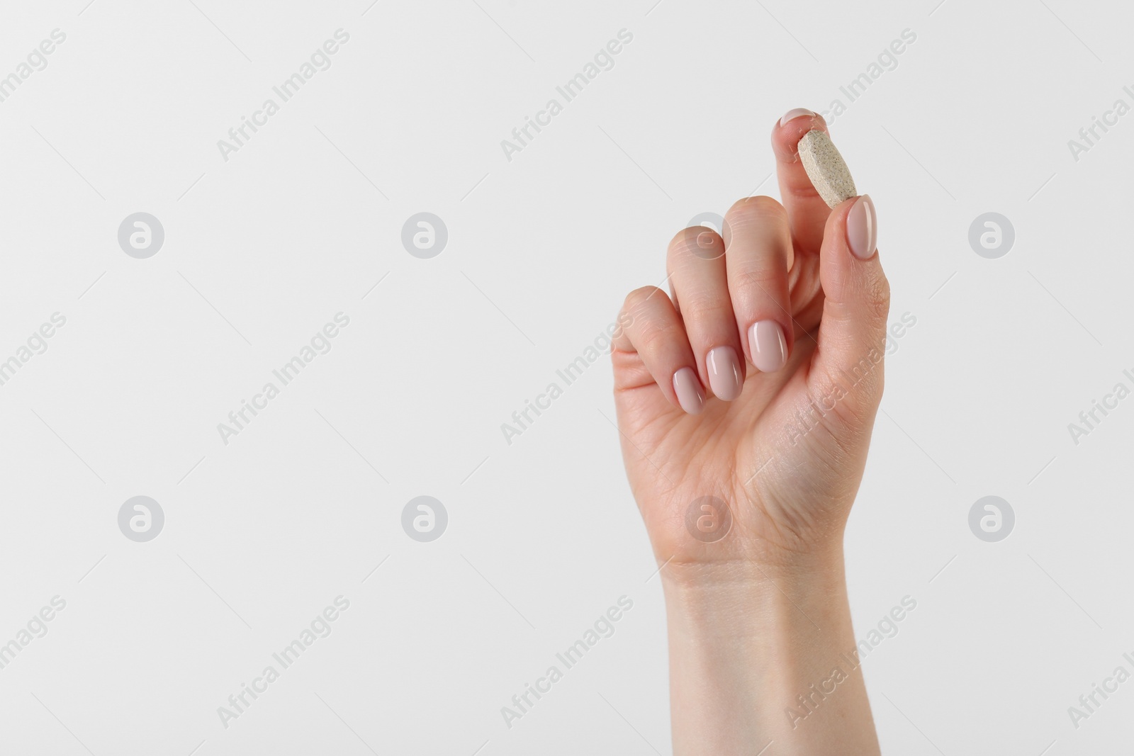 Photo of Woman holding vitamin pill on white background, closeup with space for text. Health supplement