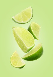 Image of Fresh lime slices falling on light green background