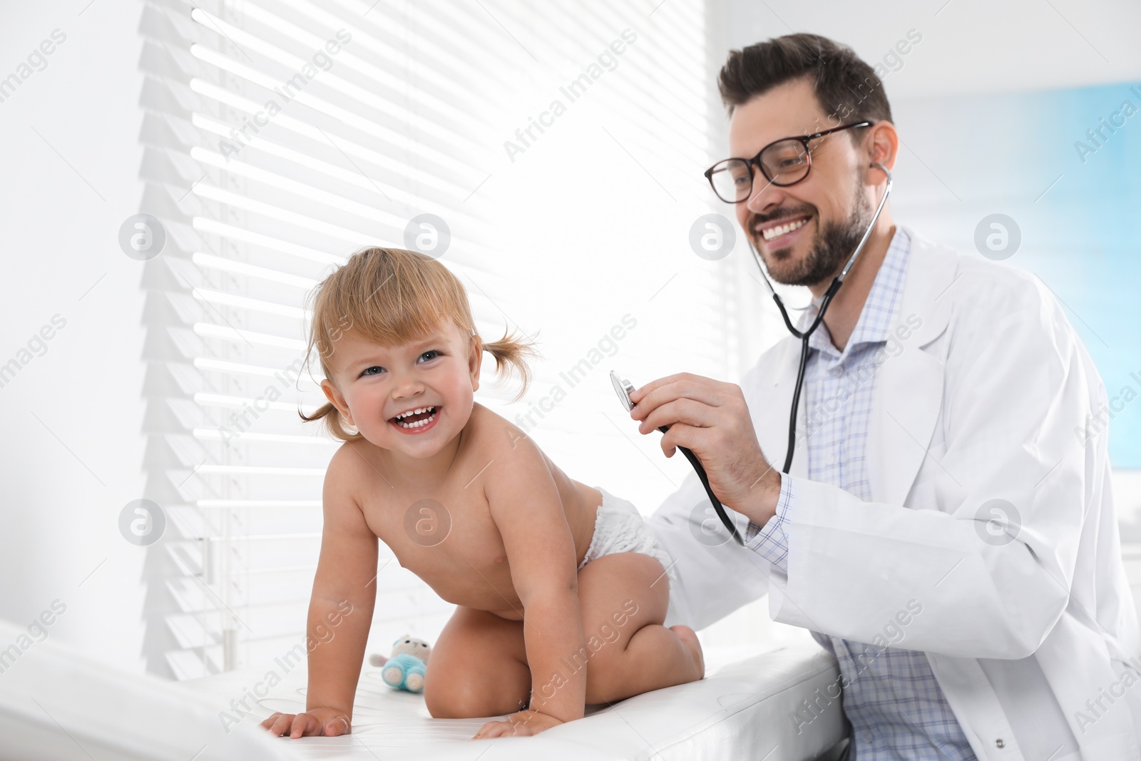 Photo of Pediatrician examining baby with stethoscope in clinic