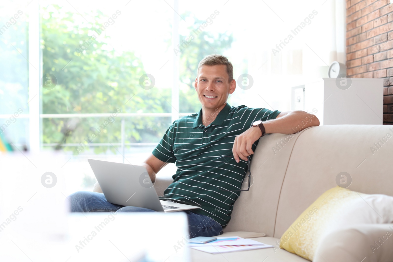 Photo of Young man working with laptop at home