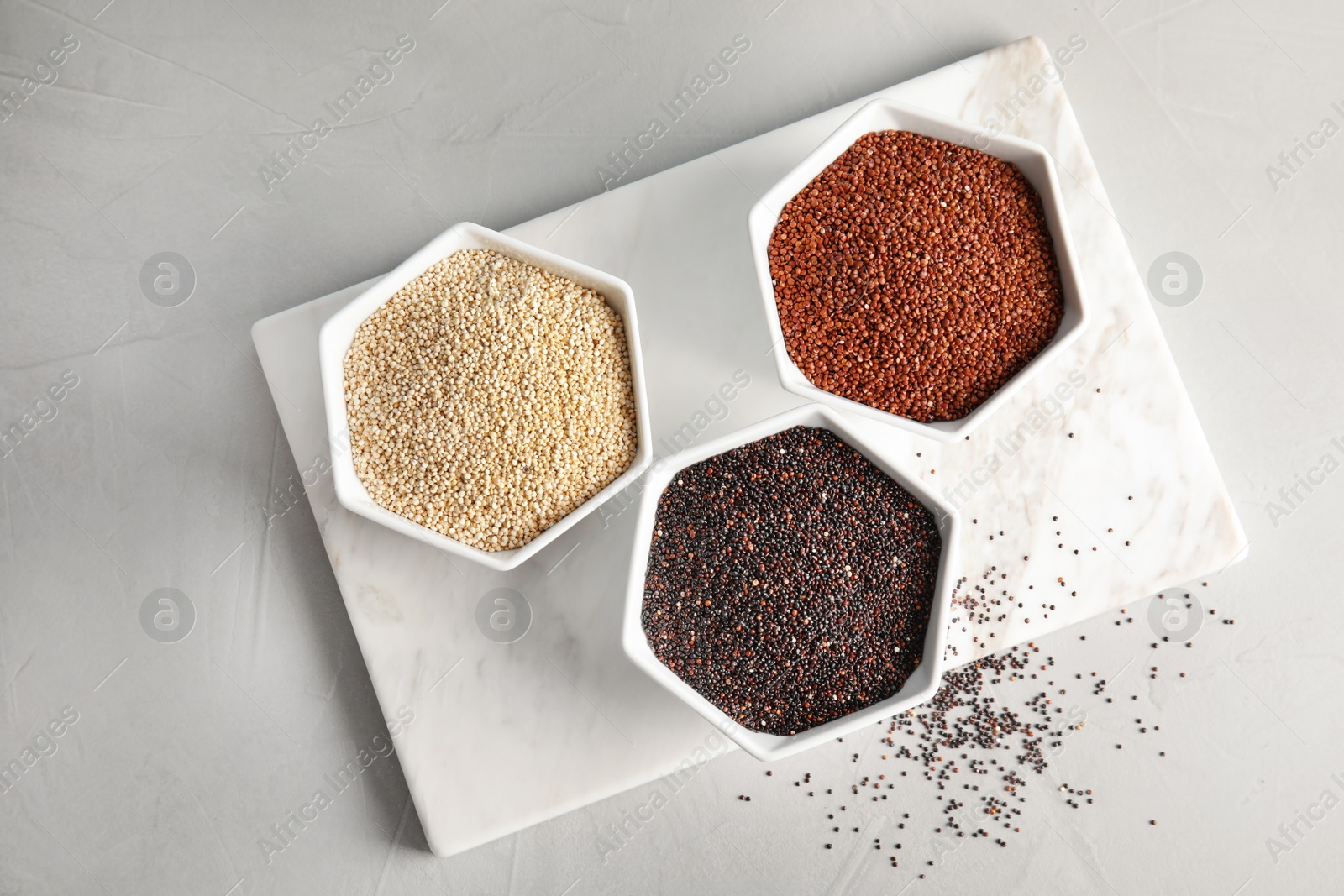 Photo of Bowls with different types of quinoa on table, top view