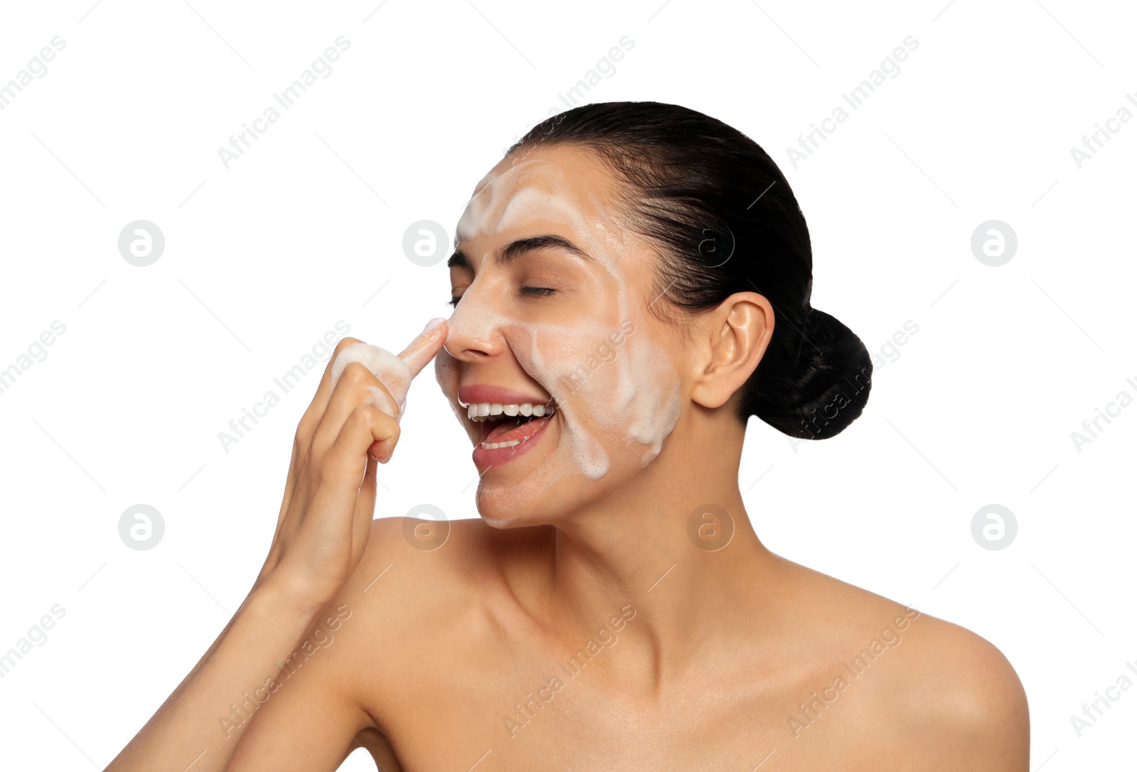 Photo of Happy young woman washing face with cosmetic product on white background