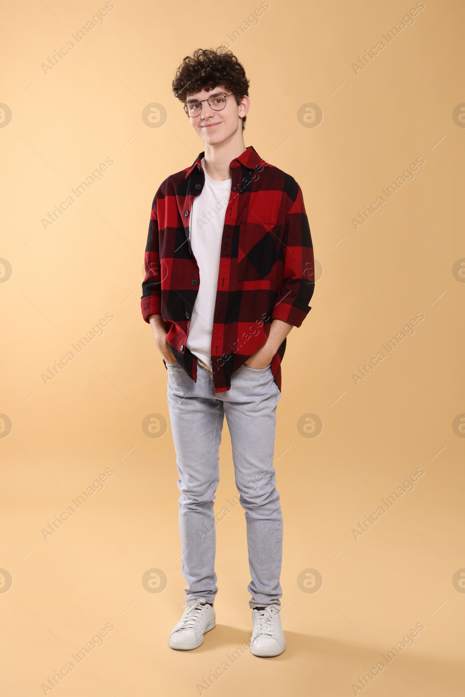 Photo of Teenage boy wearing glasses on beige background