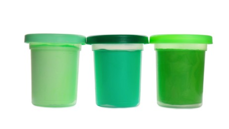 Plastic containers with different color play dough isolated on white