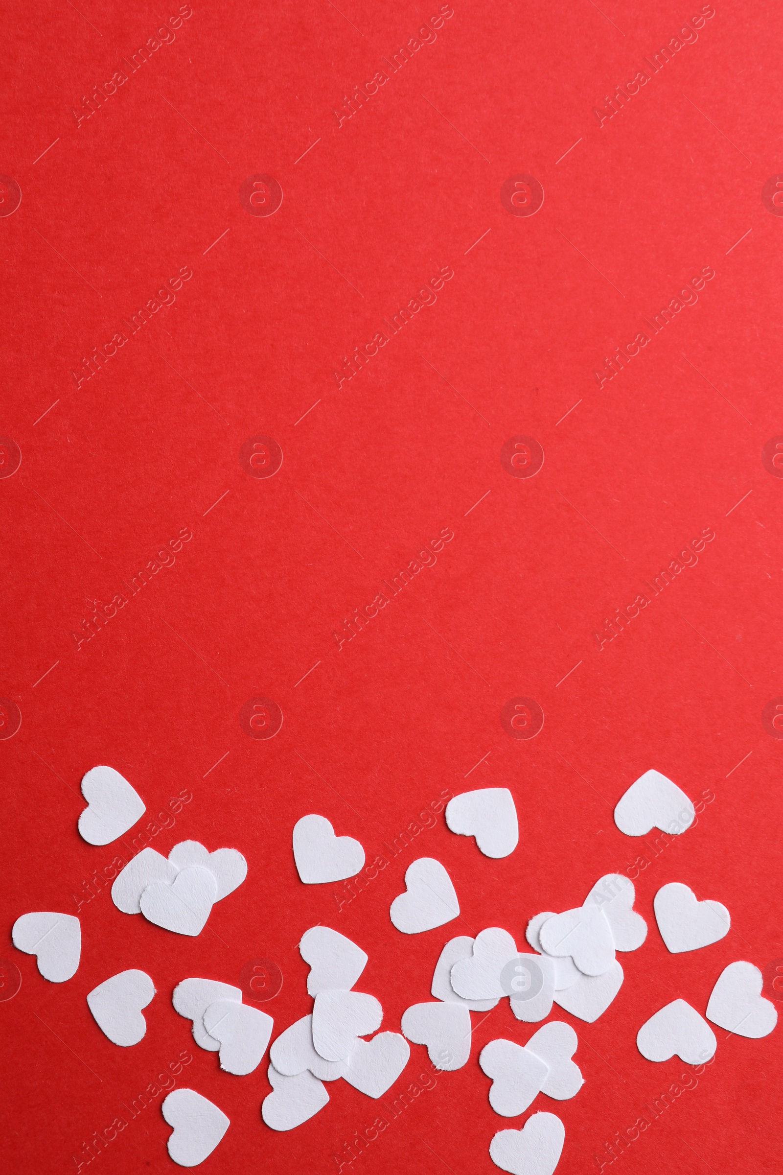 Photo of White paper hearts on red background, flat lay. Space for text