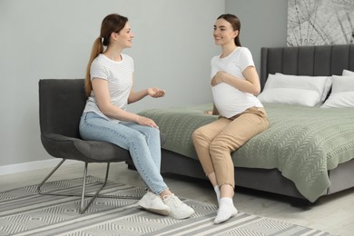 Doula working with pregnant woman in bedroom. Preparation for child birth
